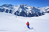 Woman back-country skiing downhill from Punta Tre Chiosis, Punta Tre Chiosis, Valle Varaita, Cottian Alps, Piedmont, Italy