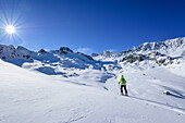 Woman back-country skiing ascending towards Rocca La Marchisa, Rocca La Marchisa, Valle Varaita, Cottian Alps, Piedmont, Italy