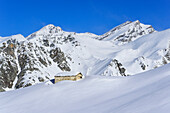 Snow covered alpine hut in front of Bric de Rubren and Monte Salza, Rocca La Marchisa, Valle Varaita, Cottian Alps, Piedmont, Italy