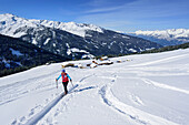 Woman back-country skiing ascending towards Gilfert, view to Nonsalm, valley of Inn and Karwendel range, Gilfert, Tux Alps, Tyrol, Austria