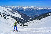 Woman back-country skiing ascending towards Halslspitze, view to Karwendel range, Halslspitze, Tux Alps, Tyrol, Austria