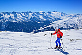 Frau auf Skitour steigt zur Halslspitze auf, Blick auf Zillertaler Alpen mit Hoher Riffler und Olperer, Halslspitze, Tuxer Alpen, Tirol, Österreich