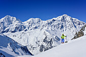 Woman back-country skiing ascending towards Vertainspitze, Koenigsspitze, Zebru and Ortler in background, Vertainspitze, valley of Sulden, Ortler range, South Tyrol, Italy