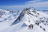 Several persons back-country skiing downhill from Pizzo Tresero, Punta San Matteo in background, Pizzo Tresero, Val dei Forni, Ortler range, Lombardy, Italy