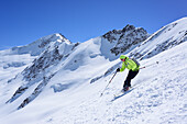 Woman back-country skiing downhill from Pizzo Tresero, Punta San Matteo in background, Pizzo Tresero, Val dei Forni, Ortler range, Lombardy, Italy