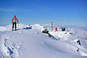 Group of persons back-country skiing standing at summit of Pallspitze, Pallspitze, Langer Grund, Kitzbuehel range, Tyrol, Austria