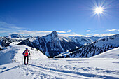 Woman back-country skiing asending towards Floch, Grosser Rettenstein in background, Floch, valley of Spertental, Kitzbuehel range, Tyrol, Austria