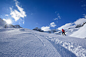 Woman back-country skiing ascending towards Monte Soubeyran, Monte Soubeyran, Valle Maira, Cottian Alps, Piedmont, Italy