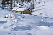 Snow-covered alpine huts at Valle Enchiausa, Valle Enchiausa, Valle Maira, Cottian Alps, Piedmont, Italys
