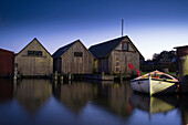 Fishing boat in front of boathouses in the harbour in Ahrenshoop am Bodden in the blue hour, Ahrenshoop, Mecklenburg Vorpommern, Germany