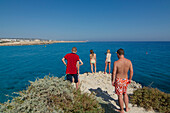Touristen auf einem Felsen am Nissi Beach bei Agia Napa nordöstlich von Larnaka, Larnaca District, Zypern
