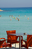 Rote Stühle im Strandcafe am weissen Strand und im Wasser, Nissi Beach bei Agia Napa nordöstlich von Larnaka, Larnaca District, Zypern