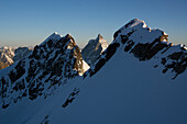 am Gipfelgrat der Roccia Nera, einem von fünf Gipfeln des Breithorn Massivs, neben ihnen grosse Wechten, Walliser Alpen, Kanton Wallis und Region Aostatal, Landesgrenze Schweiz und Italien