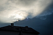 Im Dorf Soglio geht die Sonne hinter der Sciora Gruppe auf, Bergell, Bündner Alpen, Kanton Graubünden, Schweiz