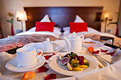 Breakfast tray on a hotel bed, Bavaria, Germany