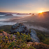 Blick vom Gleitmannshorn über den kleinen Zschand mit Nebel zum Sonnenaufgang mit Felsen im Vordergrund, Kleiner Winterberg, Nationalpark Sächsische Schweiz, Sachsen, Deutschland