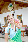 Female cyclist holding ice cream, Chiemgau, Bavaria, Germany