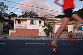 Young man running along a street, Dominica, Lesser Antilles, Caribbean