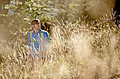 Young man hiking up a mountain on a sunny day, Oberstdorf, Bavaria, Germany