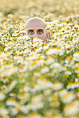 The head of a young man looking out of a flower field, Mallorca, Spain