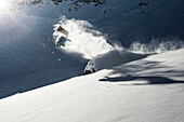 Junger Skifahrer macht einen Backflip über einen Felsen, Pitztal, Tirol, Österreich