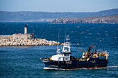 Fischerboot und Leuchtturm an der Einfahrt zum Hafen, A Coruna, Galicien, Spanien, Europa
