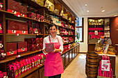 Fröhliche Verkäuferin mit belgischen Pralinen und Schokolade im Brugerren Süßwarengeschäft, Brügge, Flandern, Belgien, Europa