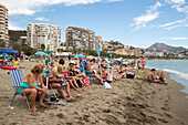 Pensioners at Playa de la Malagueta beach with high-rise apartment buildings, Malaga, Costa del Sol, Andalusia, Spain