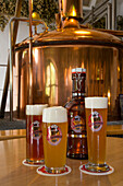 Glasses of Bergbier, Storchenbier and Goldblondchen Weizen beer on display in front of brew kettle at Steinbach Bräu brewery, Erlangen, Franconia, Bavaria, Germany