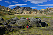 Hikers at trekking trail Laugavegur crossing colorful mountains and lava fields, Landmannalaugar, Highlands, Southern Iceland, Iceland, Europe