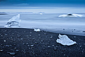 Blue Icebergs and drift ice at black lava beach from glacier lake Jokulsarlon at Vatnajökull near Skaftafell National Park, East Iceland, Iceland, Europe
