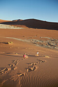 Zwei Jungen rennen Sanddüne hinunter, Deadvlei, Sossusvlei, Namib-Naukluft-Nationalpark, Namibia
