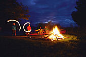 Family at bonfire, lake Staffelsee, Seehausen, Upper Bavaria, Germany