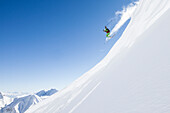 freeride skier jumps over snow cornice, Zugspitze, Hochwanner in the background, Upper Bavaria, Germany