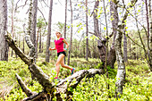 young woman running in a moorland forest, Berg at Lake Starnberg, Upper Bavaria, Germany