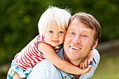 two-year-old girl on her father's back, Speyer, Rheinland-Pfalz, Germany