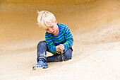 Junge, 4 Jahre, spielt mit Sand am Strand von Portals Vells, Mittelmeer, MR, bei Magaluf, Mallorca, Balearen, Spanien