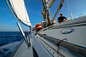 A young man sitting on the deck of a sailing yacht, Mallorca, Balearic Islands, Spain, Europe