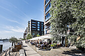 People sitting at Dalmannkai in Hafencity, Hamburg, Germany