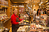 Frau verkauft Pralinen in einem Geschäft für Süßwaren und Schokolade in der Altstadt, Brügge, Flandern, Belgien, Europa
