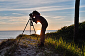 Fotografin an der Ostseeküste bei Sonnenuntergang, Darßer Weststrand, Darß, Mecklenburg-Vorpommern, Deutschland
