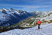Woman back-country skiing ascending towards Schrammacher, valley of Pfitsch in background, Schrammacher, valley of Pfitsch, Zillertal Alps, South Tyrol, Italy