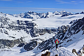 Woman back-country skiing descending ridge from Aeusserer Baerenbartkogel, Aeusserer Baerenbartkogel, valley of Langtaufers, Vinschgau, Oetztal Alps, South Tyrol, Italy