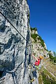 Frau begeht steilen Klettersteig, Pidinger Klettersteig, Hochstaufen, Chiemgauer Alpen, Chiemgau, Oberbayern, Bayern, Deutschland