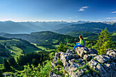 Woman hiking sitting on Besler and looking towards Allgaeu Alps, Besler, valley of Balderschwang, Allgaeu Alps, Allgaeu, Svabia, Bavaria, Germany