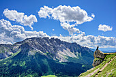 Bronze eagle standing on ledge, Latemar in background, Rotwand, Rosengarten, UNESCO world heritage Dolomites, Dolomites, Trentino, Italy