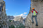 Woman doing fixed rope route towards Rotwand, Rotwand, Rosengarten, UNESCO world heritage Dolomites, Dolomites, Trentino, Italy