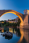 Bridge over river illuminated at dusk, Mostar, Herzegovina, Bosnia-Herzegovina, Mostar, Herzegovina, Bosnia-Herzegovina