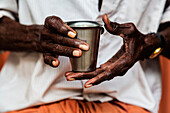 Man's hands holding cup of tea, Alleppey, Kerala, India