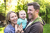 Caucasian couple holding baby in backyard, Los Angeles, California, USA
